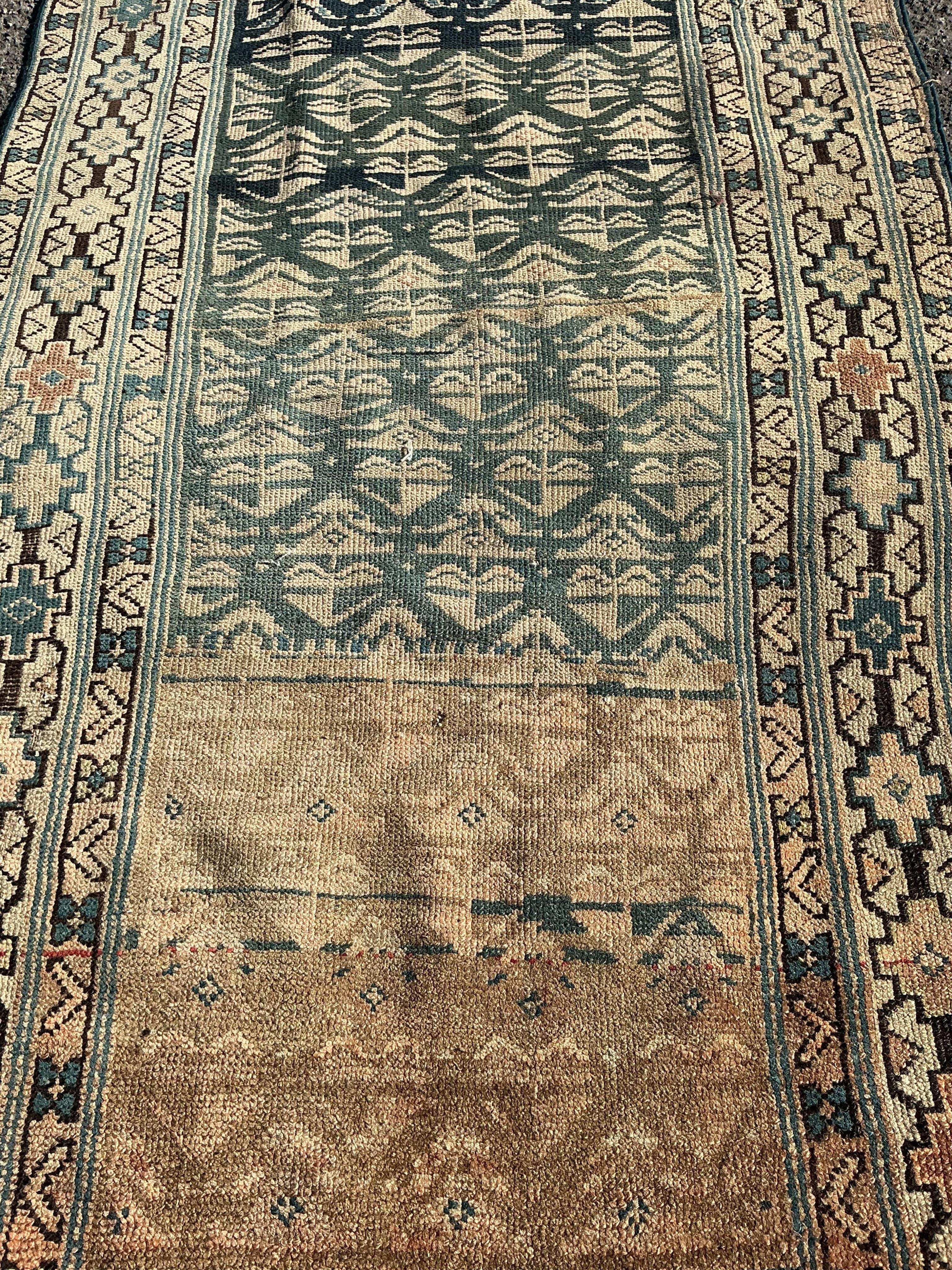 An antique Caucasian blue ground runner, heavily worn and faded, 342 x 96cm